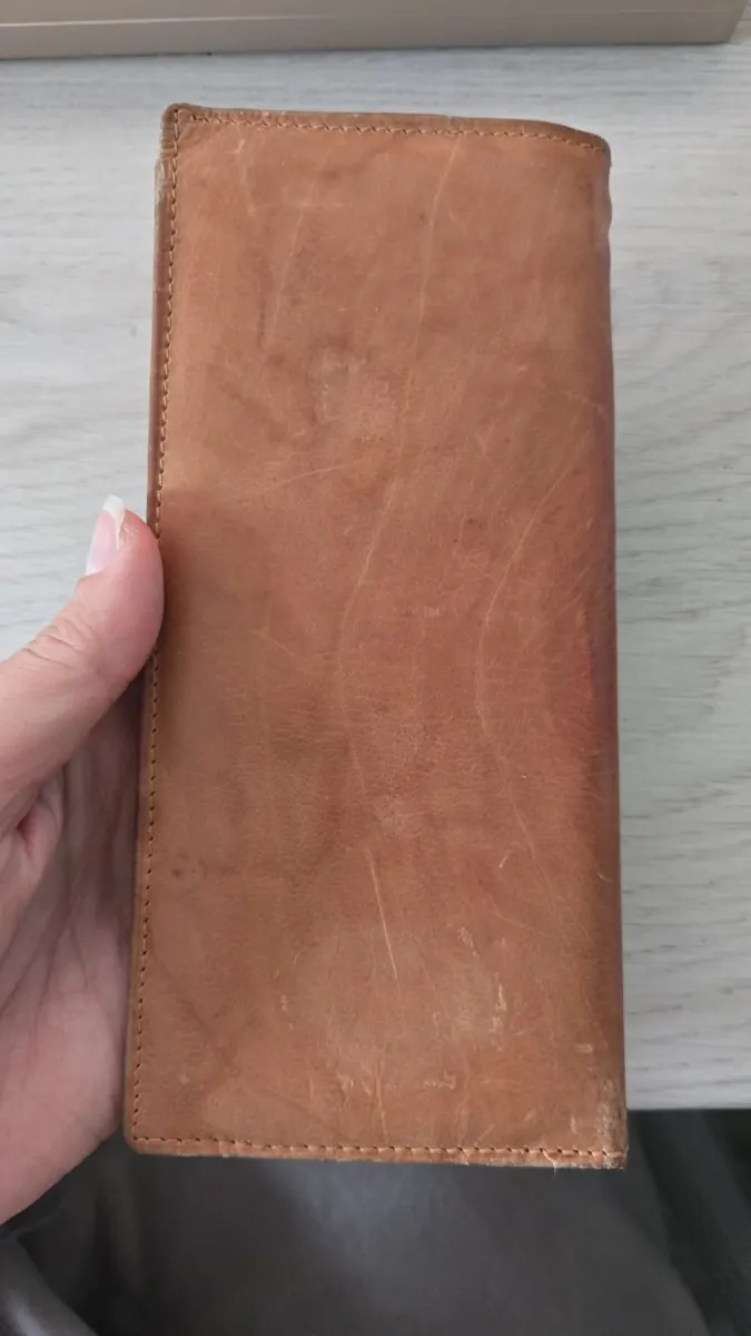 Lottie’s timeworn tan leather purse held in Gemma’s hand